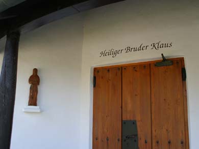 Eingangstüre und Holzfigur vom "Heiligen Bruder Klaus"
