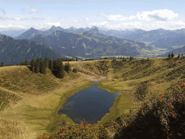 Rückblick auf den mittleren Gipfel. Zahlreiche Pfade führen hier an den Hängen hinunter. Um den See herum ist ein breiter Sumpfgürtel, so dass wir nicht an sein Ufer heran kommen konnten. Wir steigen den gleichen Weg wieder zur Buchel-Alpe hinunter.